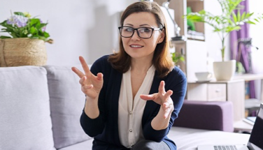 Lady in glasses expressing something with hand gestures