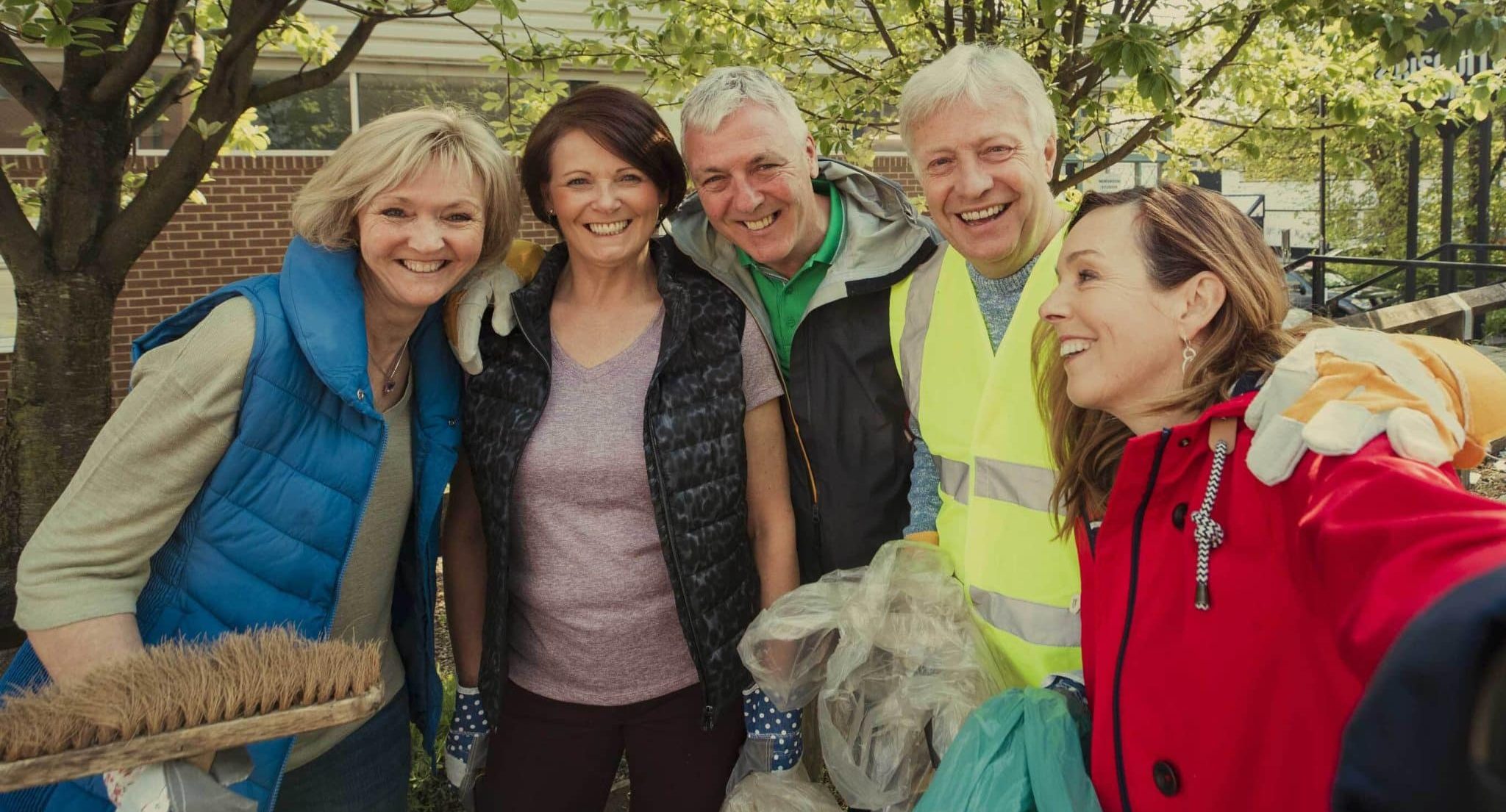 Group of happy people cleaning the streets