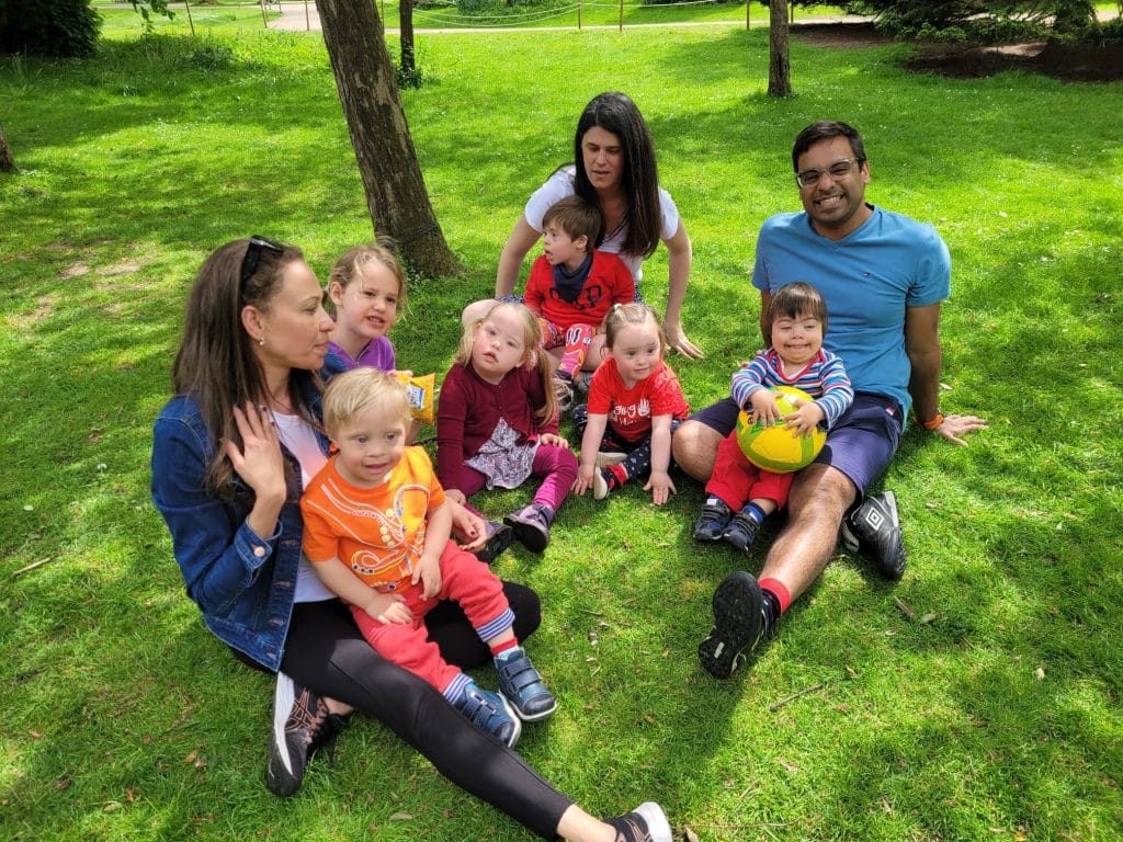 Group of Adults and Children sitting on the grass