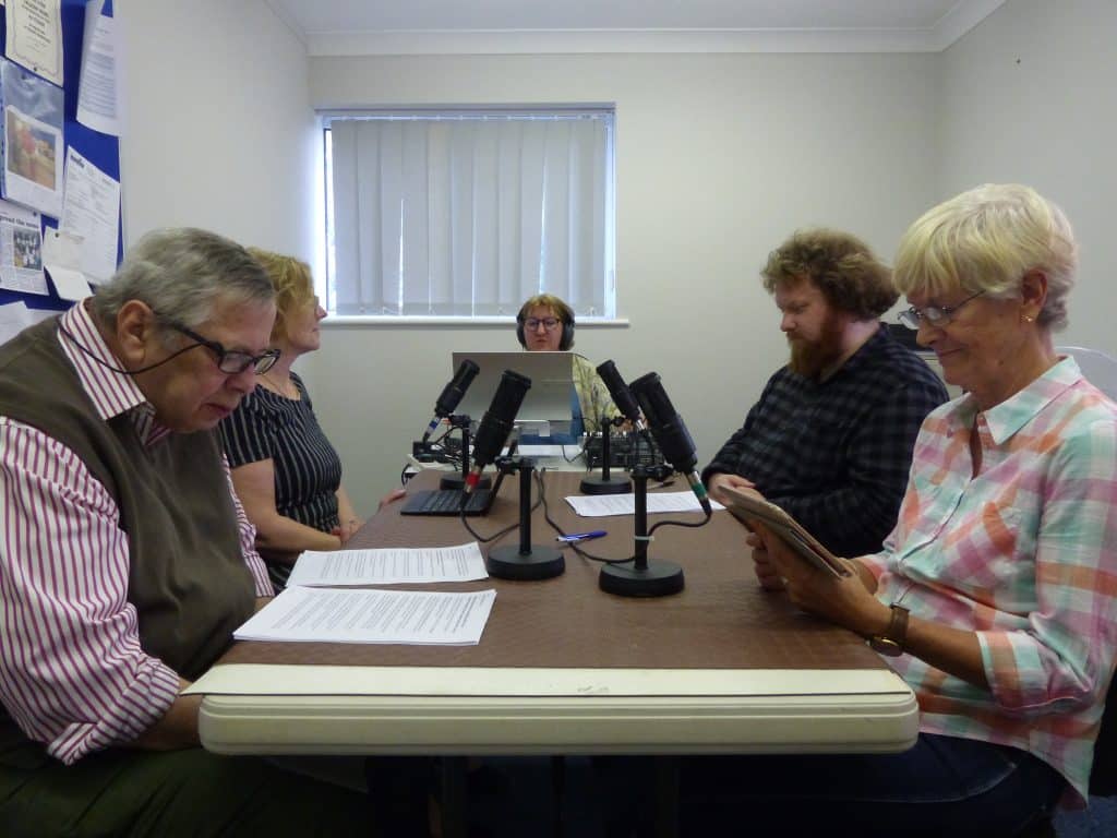Group of people recording a newspaper